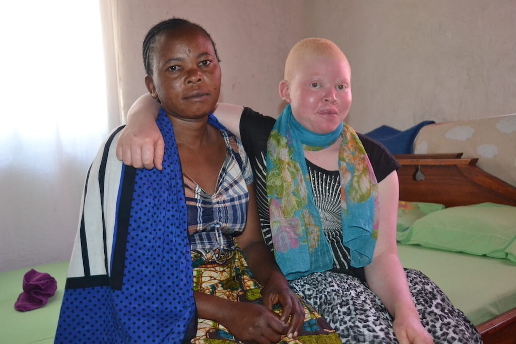 Grace and her mother sit on a bed.